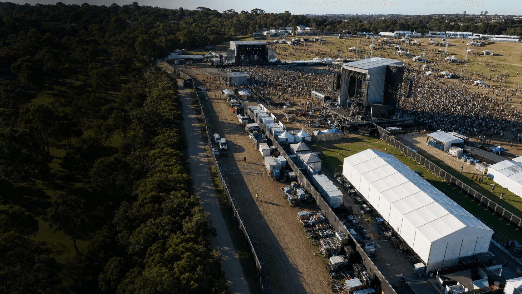 An outdoor music festival with multiple stages and production areas
